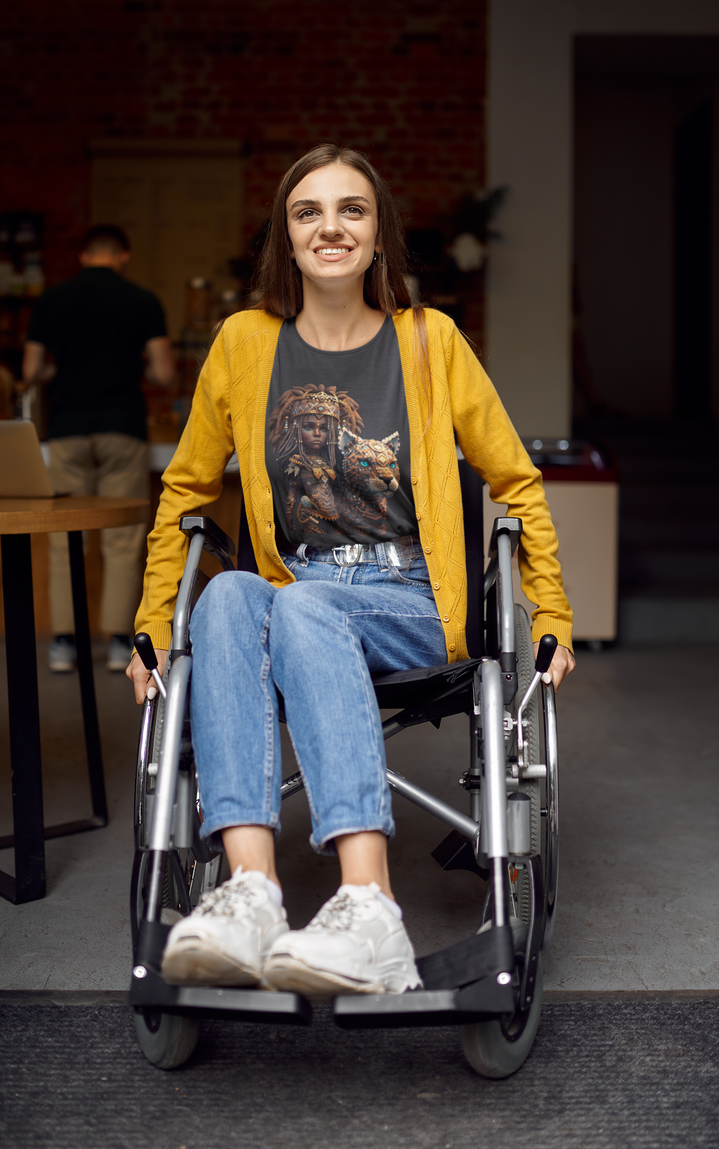 dark grey colour t-shirt which has a design of a pop anime African princess with her leopard pet worn by a happy young woman using a wheelchair