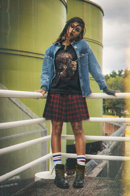 black colour t-shirt which has a design of a pop anime African princess with her leopard pet worn by a woman with locs in a grunge style outfit